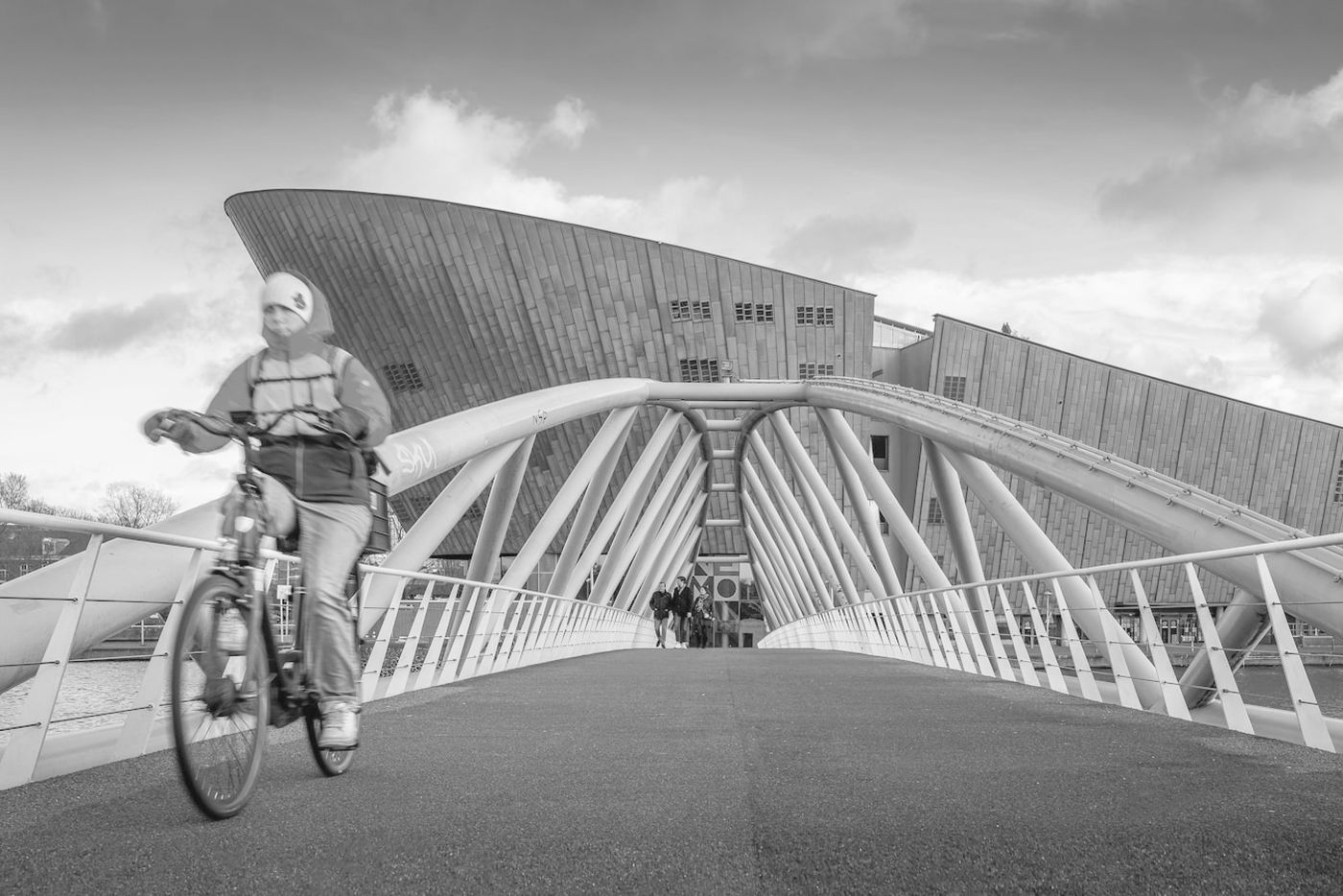 A cyclist crossing a modern city bridge